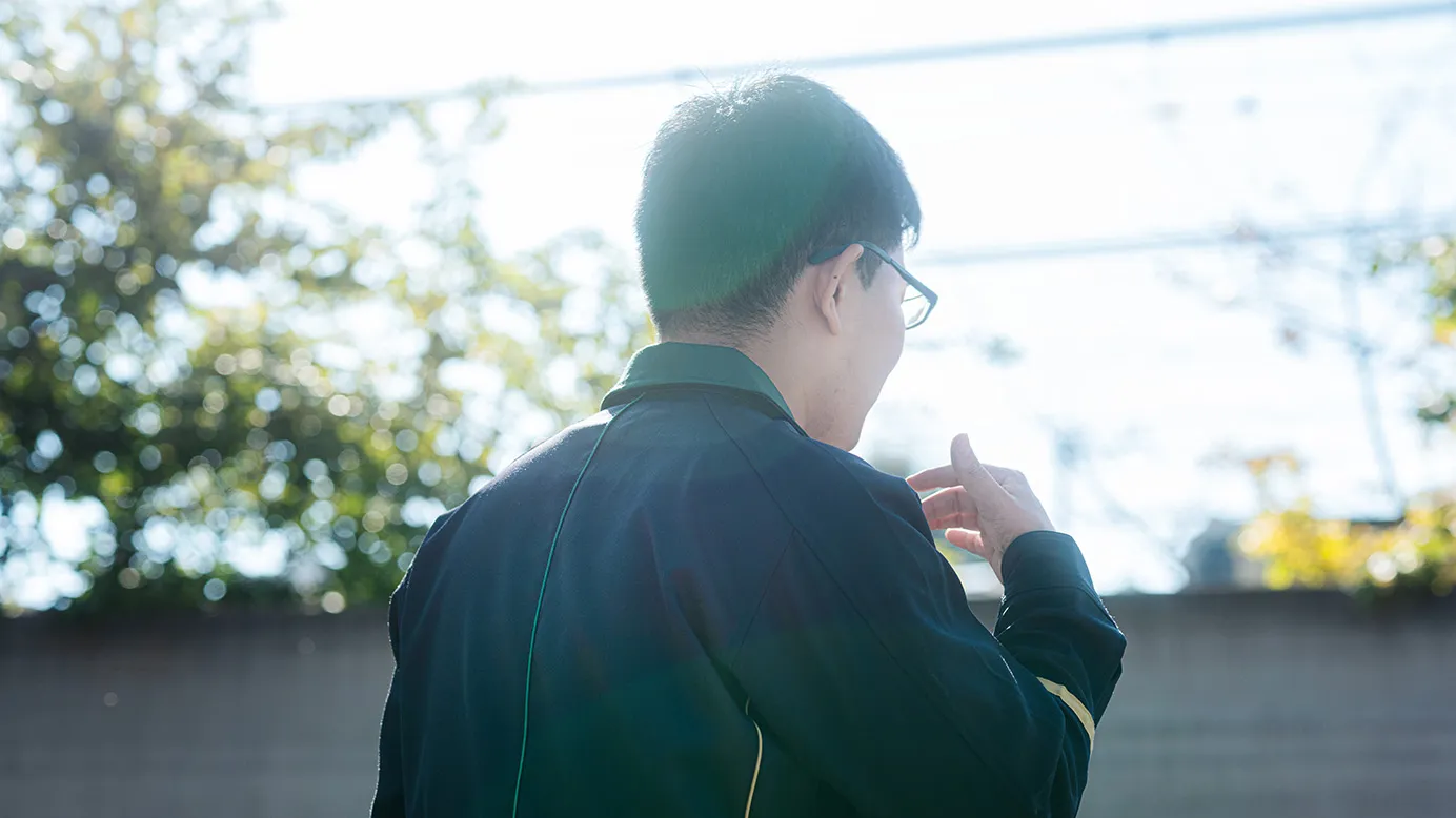 屋外で前を向く社員の後ろ姿を写した写真